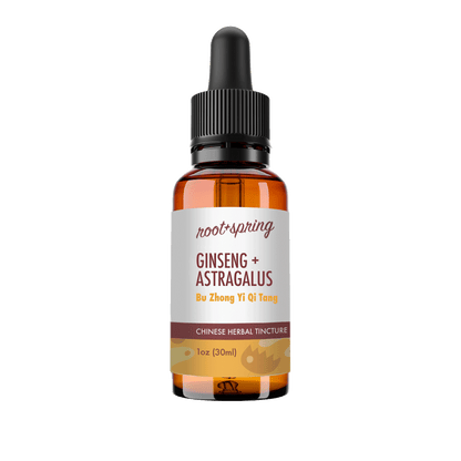 A 1 oz amber glass dropper bottle of Root+Spring Ginseng + Astragalus herbal tincture, featuring a white label with brown text and a black dropper cap, set against a plain white background.