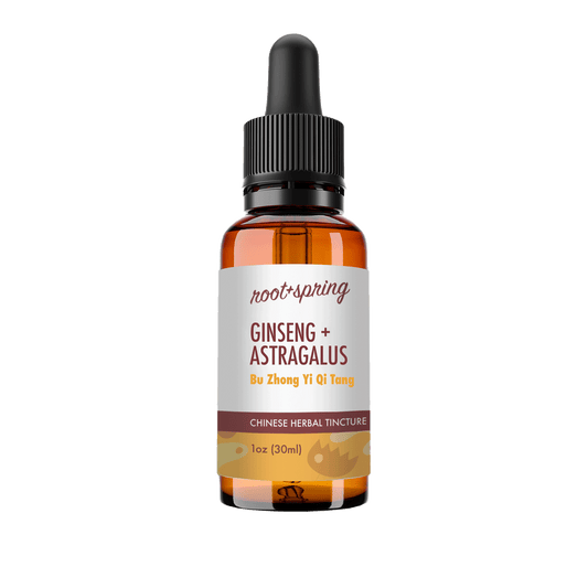 A 1 oz amber glass dropper bottle of Root+Spring Ginseng + Astragalus herbal tincture, featuring a white label with brown text and a black dropper cap, set against a plain white background.