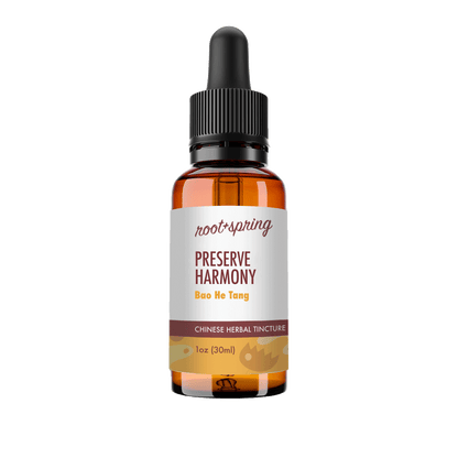 A 1 oz amber glass dropper bottle of Root+Spring Preserve Harmony Chinese Herbal Tincture, featuring a white label with brown and yellow text, and a black dropper cap, isolated on a white background.